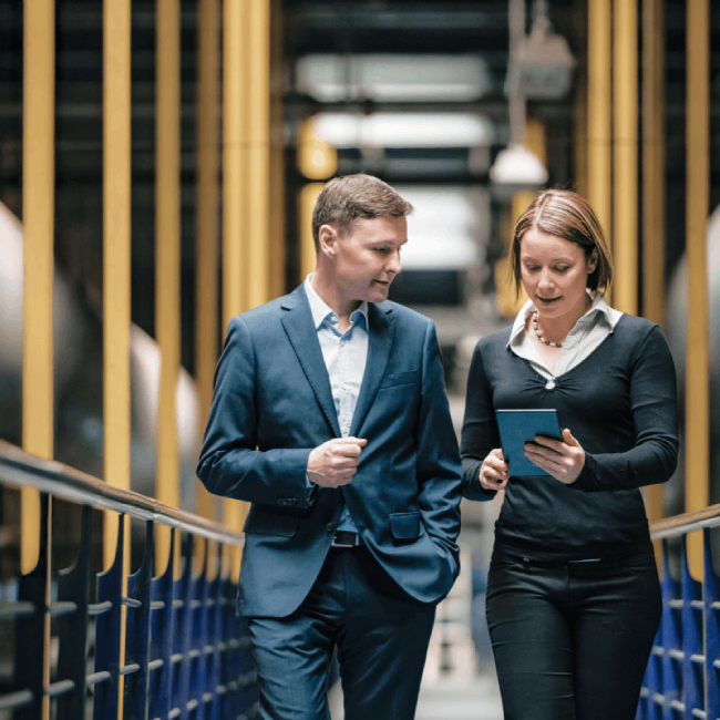 Two people looking at a server walking down hall.