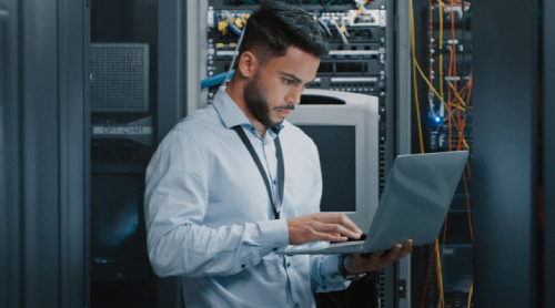 Two people looking at a server rack.