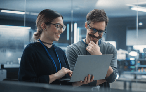 Two people looking at a server rack.